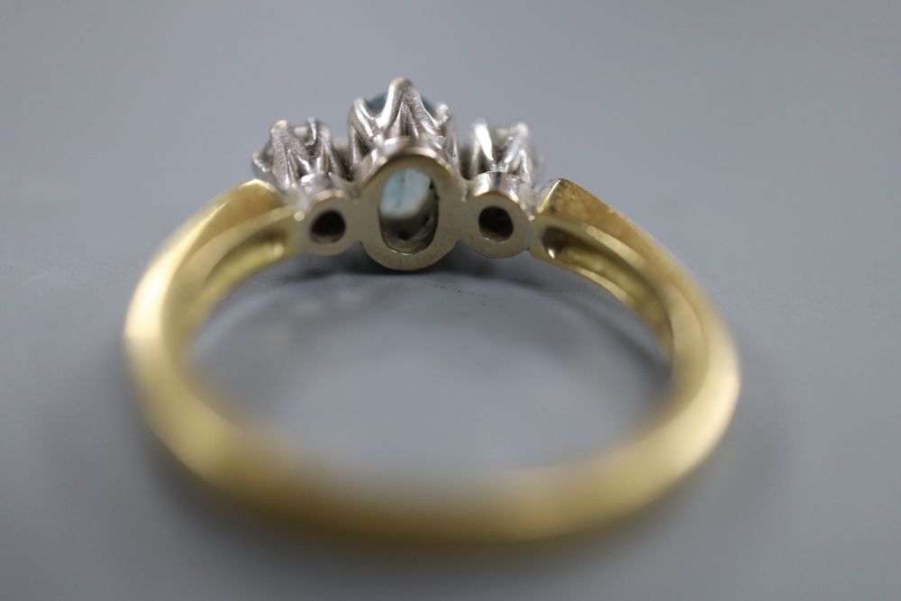 A modern 18ct gold, aquamarine and diamond three-stone ring, size M, gross 5 grams.